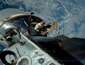 In een omloopbaan rond de aarde neemt astronaut Dave Scott een kijkje buiten de commandomodule van Apollo 9