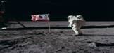 Apollo 11astronaut Edwin Buzz Aldrin poseert met de Amerikaanse vlag die in de Mare Tranquillitatis op de maan is geplant Wie goed kijkt kan Aldrins gezicht door het vizier van zijn helm ontwaren